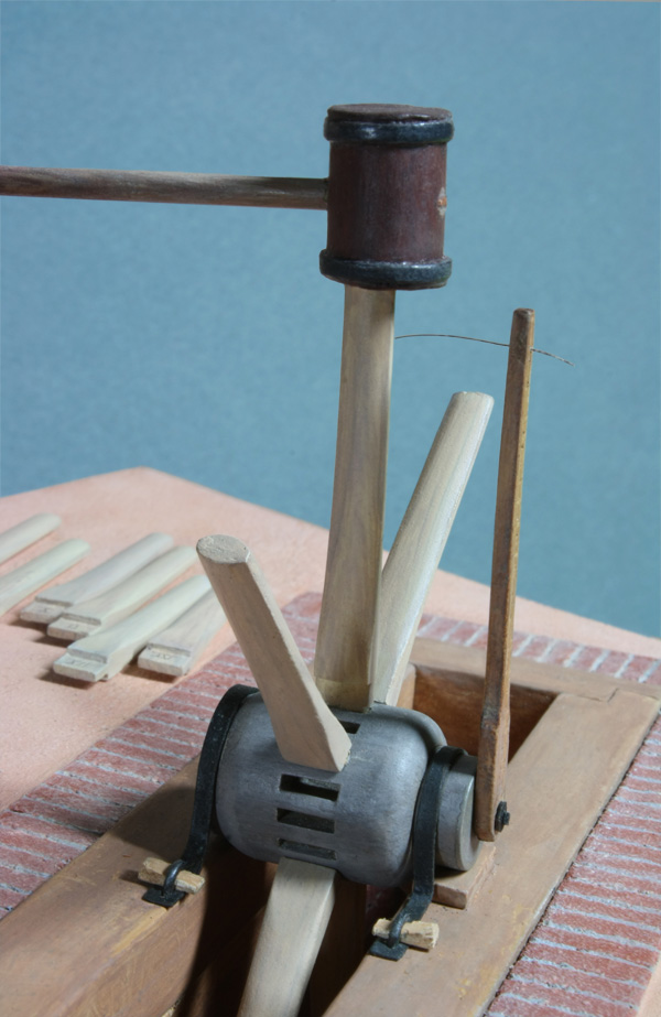 Close-up of 1/20th scale Conestoga wheel hub with spokes being driven in