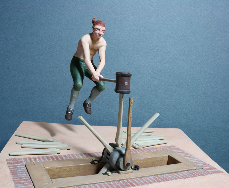 18th-century wheelwright driving spokes into wagon wheel, 1/20th scale